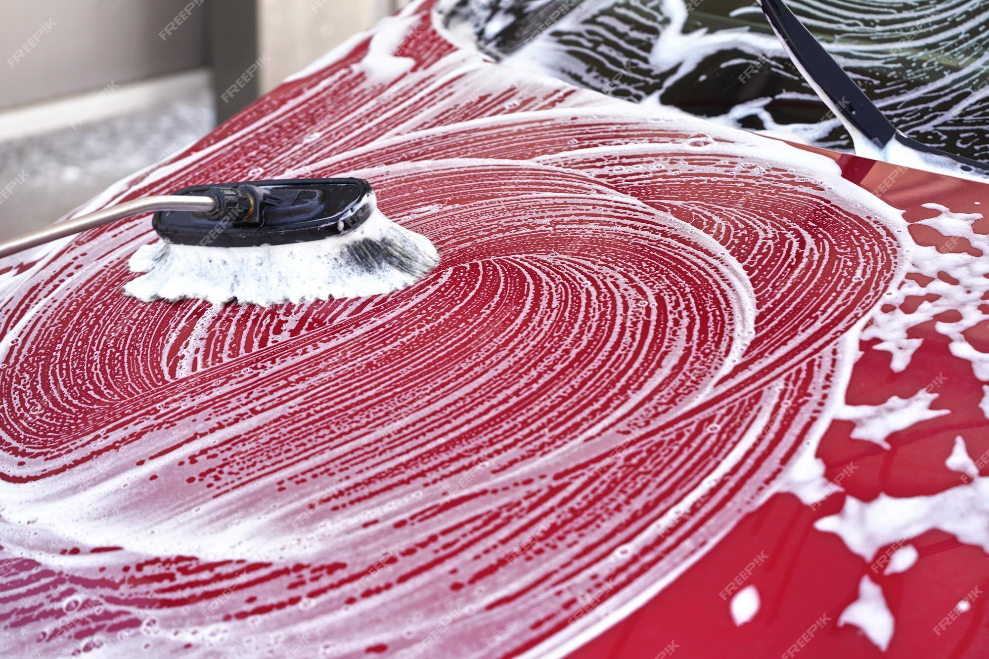 capot-avant-voiture-rouge-lave-dans-lave-auto-libre-service-detail-brosse-laissant-traits-dans-mousse-savon-blanche_692357-6907